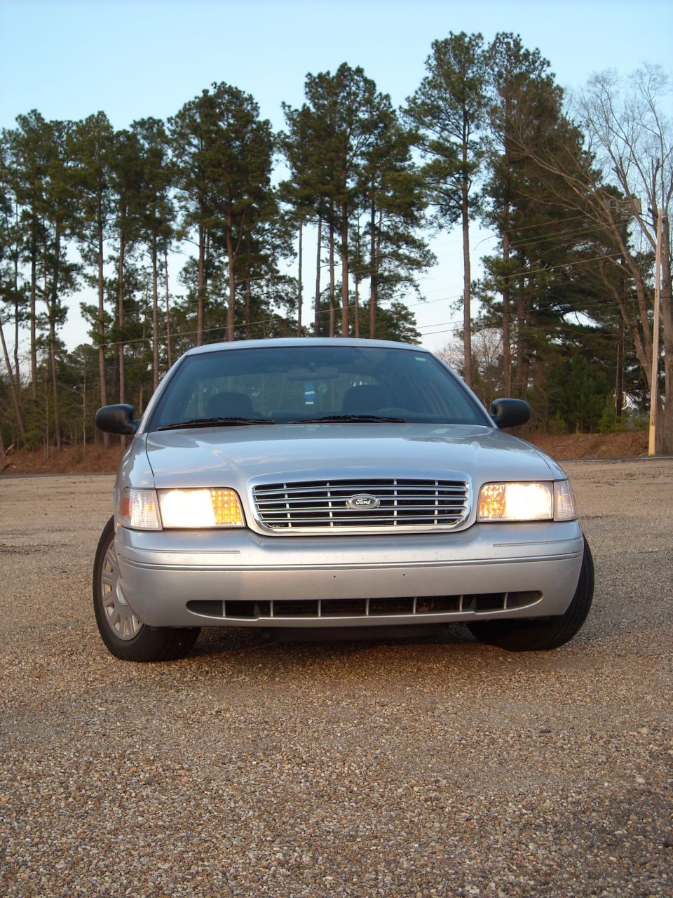 Front view of a silver 2003 Ford Crown Victoria parked on a gravel lot