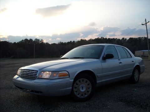 2003 Ford Crown Victoria - A silver 2003 Ford Crown Victoria is parked outdoors under a cloudy sky.