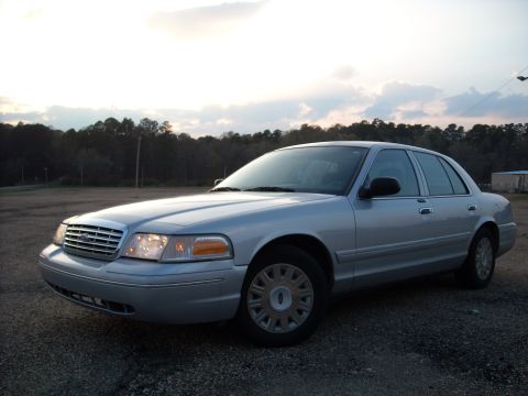 2003 Ford Crown Victoria - Silver 2003 Ford Crown Victoria sedan parked outdoors with trees in the background.