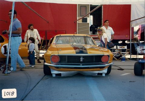 1973 Ford Mustang - A 1970 Ford Mustang Boss 302 race car is parked in front of a red trailer with people around.