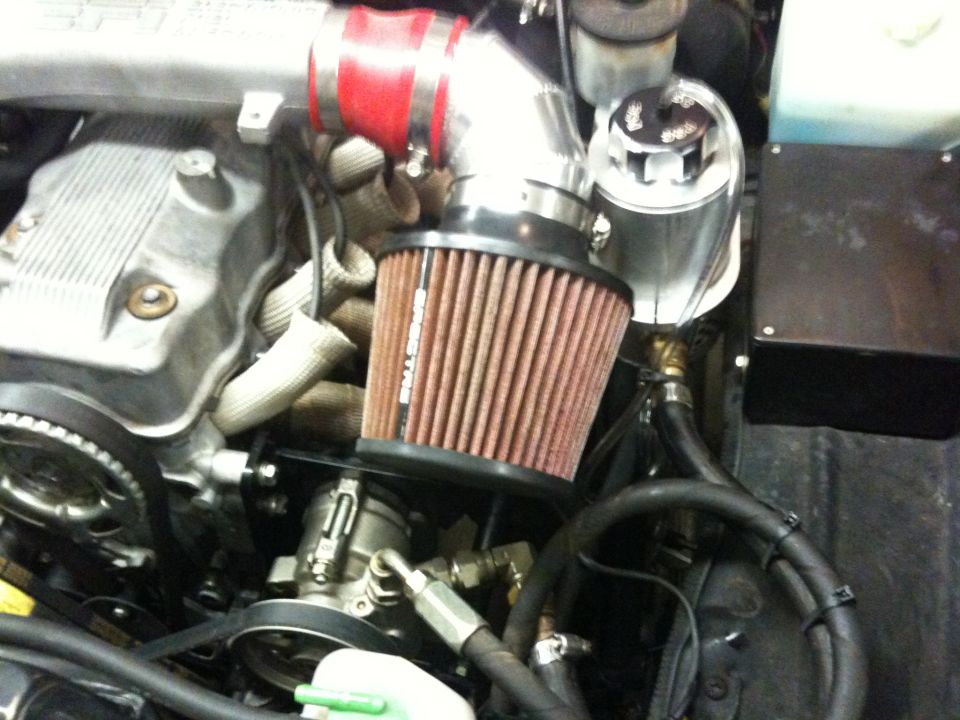 Engine bay with aftermarket air intake and red hose