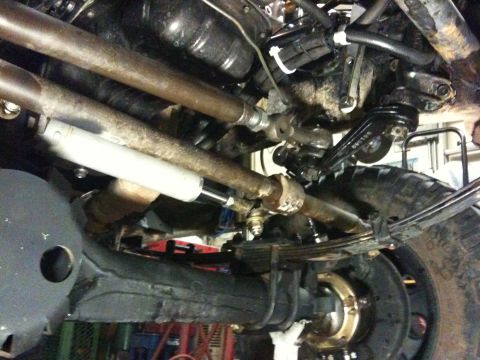 1987 Suzuki Samurai - Close-up of steering and suspension parts from underneath a vehicle.