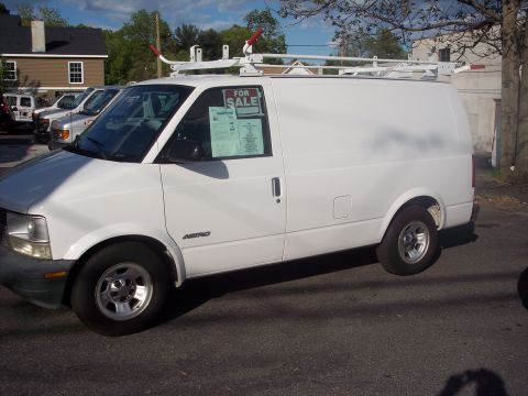 2006 Chevrolet Corvette - A white cargo van equipped with a ladder rack is parked on a street, with a 'For Sale' sign visible in the window.