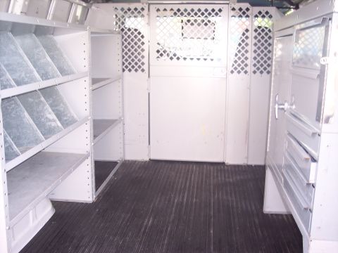 2006 Chevrolet Corvette - The interior of a cargo van is shown, extensive shelving and diamond plate partitions.