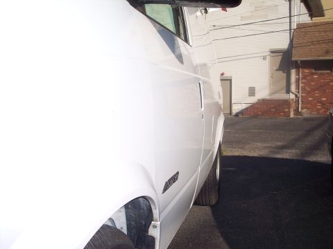 2006 Chevrolet Corvette - Side view of a white van parked in a lot.