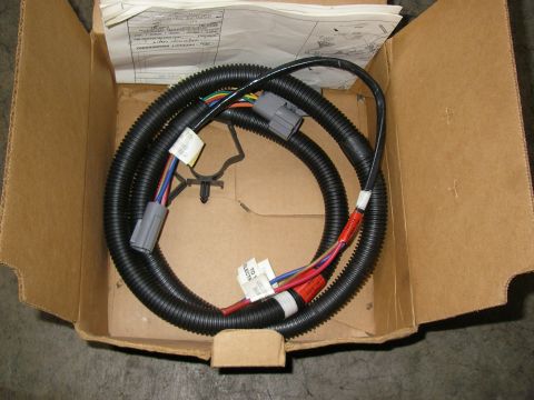 1990 Ford Bronco - coiled black automotive wiring harness with white and red connectors and instructions inside a shipping box.