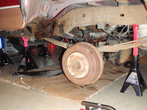 1995 Ford Bronco - The rear suspension system of a vehicle is shown elevated on jack stands, revealing its components for maintenance or after maintenance.
