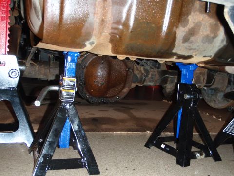 1995 Ford Bronco - Vehicle's rear differential and suspension components are supported by jack stands for maintenance.