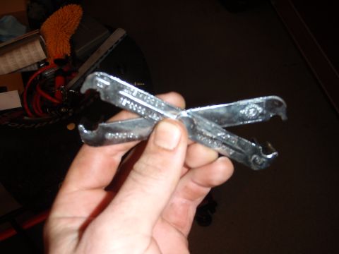 1995 Ford Bronco - A hand holds a pair of specialized pliers designed for removing and installing hose clamps.