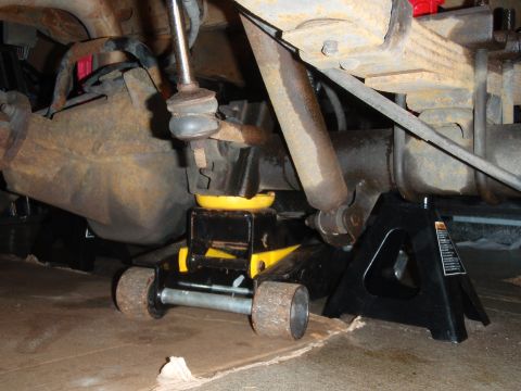 1995 Ford Bronco - Vehicle's rear suspension is elevated using a hydraulic jack and secured with a jack stand.