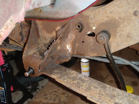 1995 Ford Bronco - Close-up view of heavily rusted vehicle suspension components, showing a leaf spring and bracket.
