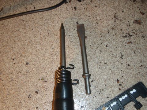 1995 Ford Bronco - Air hammer with chisel and point bits resting on a concrete surface.