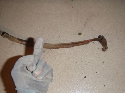 1995 Ford Bronco - A rusty leaf spring is shown, with a gloved hand in the foreground.