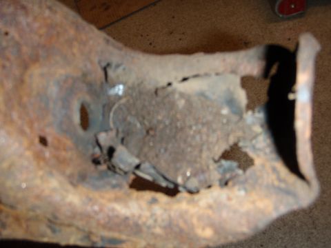 1995 Ford Bronco - Close-up of a corroded automotive suspension part, likely from the rear.