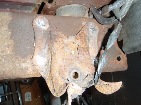 1995 Ford Bronco - Close-up of heavily corroded vehicle suspension component with visible wiring.