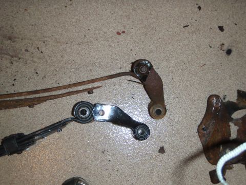 1995 Ford Bronco - Comparison of old, rusted suspension links and a newer replacement part on a concrete surface.