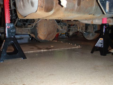 1995 Ford Bronco - The rear axle and suspension components of a 1995 Ford Bronco are visible while supported by jack stands.