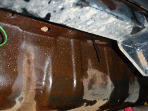 1995 Ford Bronco - Undercarriage part shows significant rust and wetness, with some green and black wires.