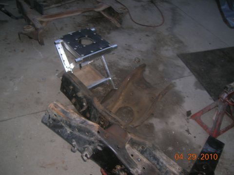 1985 Ford Bronco - The photo shows disassembled vehicle frame components and a custom-made metal jig on a workshop floor.