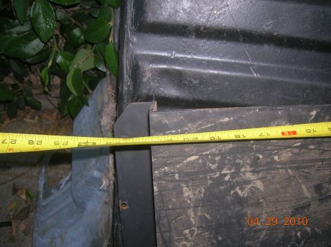 1985 Ford Bronco - A measuring tape is placed across a textured surface, with foliage visible to the left and a date stamp in the lower right corner.