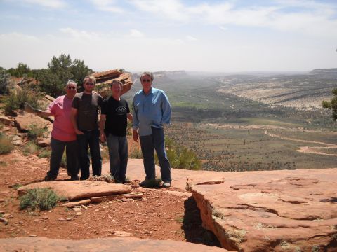 1986 Ford Bronco II - Four men pose for a photo on a scenic overlook in a desert region, with a wide valley stretching out before them.