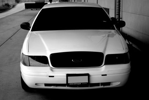 1998 Ford Crown Victoria - Front view of a white 1998 Ford Crown Victoria, a blacked-out grille and tinted headlights.