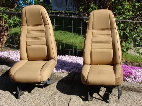 1979 Jeep CJ7 - A pair of tan bucket seats, likely from an older vehicle, are displayed outdoors.