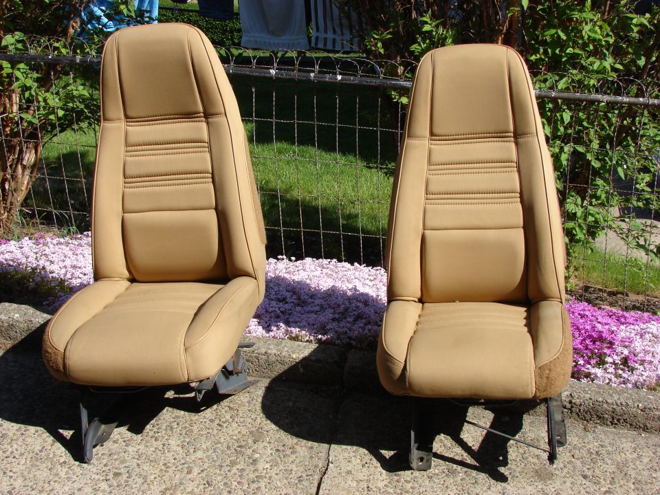 Two tan bucket seats with horizontal stitching detail