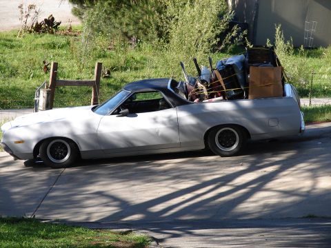 1973 Ford Ranchero - This vehicle is loaded with items in its bed, including chairs and boxes, and is parked on a driveway.