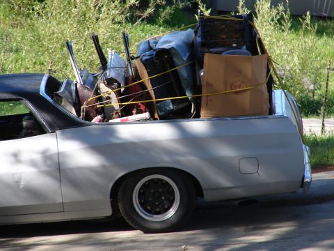 1973 Ford Ranchero - A white Ford Ranchero is heavily loaded with various items secured by yellow straps.