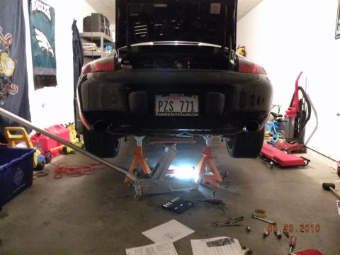 2000 Porsche Carrera - Porsche 911 rear end on jack stands, showing the license plate PZ5 771 and exhaust pipes.