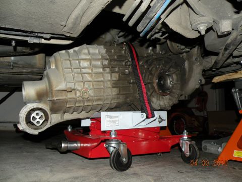 2000 Porsche Carrera - A vehicle's transmission is supported by a red rolling jack, likely during maintenance or repair.