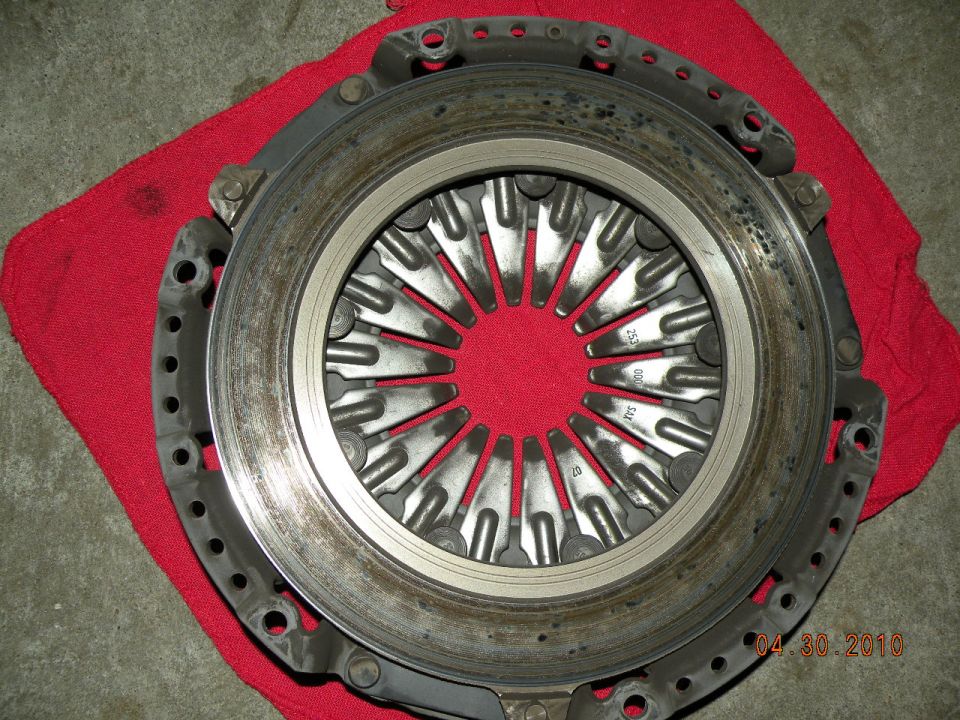 Used clutch pressure plate with diaphragm spring fingers lying on a red shop rag