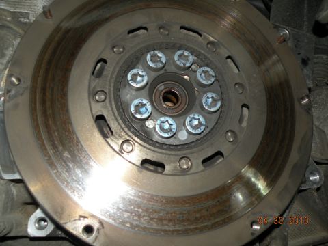 2000 Porsche Carrera - Close-up view of a clutch pressure plate and flywheel assembly, showing signs of wear and eight Torx bolts securing the plate.