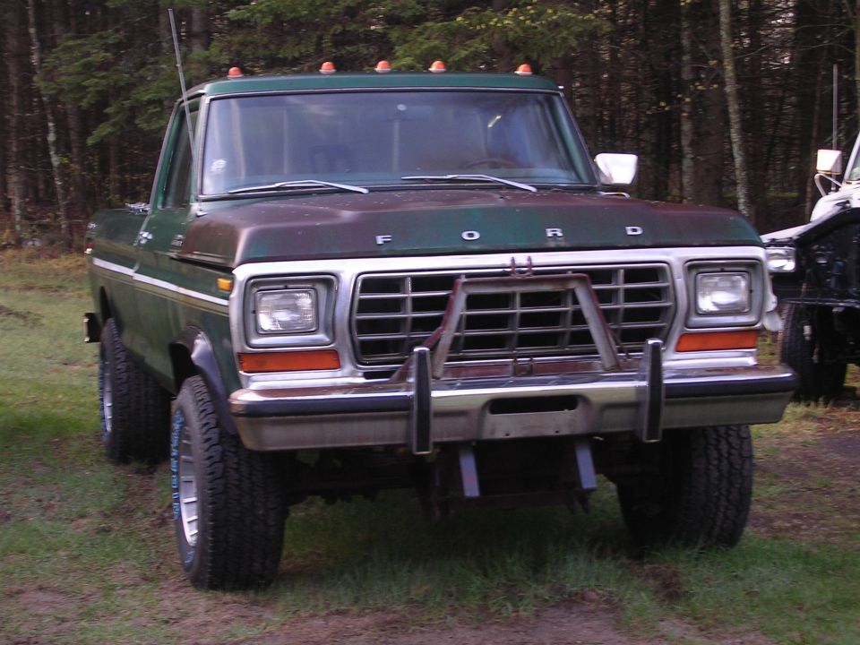 Green Ford truck front view with push bar and roof lights. Text reads "FORD"