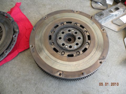 2000 Porsche Carrera - A car's clutch and flywheel assembly is shown on a concrete surface next to a red cloth.