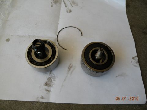 2000 Porsche Carrera - Two automotive bearings and a circlip are shown on a white surface, with visible smudges and a date stamp.