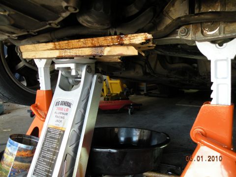 2000 Porsche Carrera - Car maintenance in progress, underside view showing jack stands and a racing jack.
