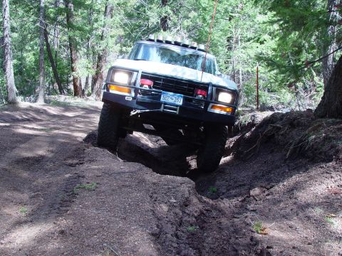 1993 Ford Bronco - This 1993 Ford Bronco tackles a challenging off-road trail with its front wheels navigating a deep rut.