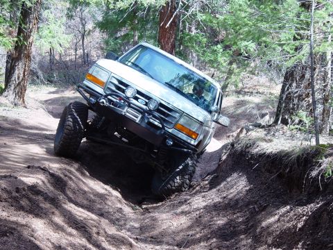 1993 Ford Bronco - Ford Bronco tackles challenging off-road terrain on a sunny day.