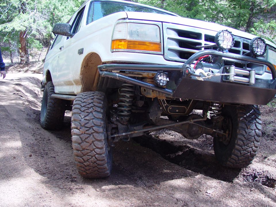 1993 Ford Bronco with aftermarket bumper and winch on a dirt trail