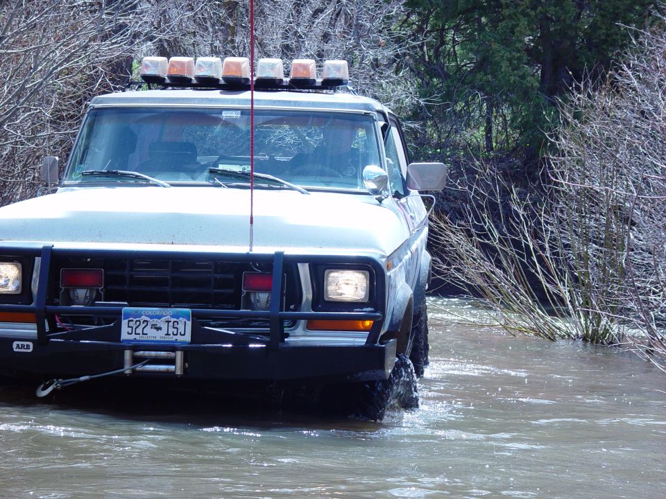 1980-1986 Ford Bronco driving through water with light bar
