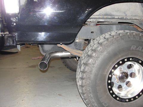 1995 Ford Bronco - The rear tire and exhaust system of a vehicle are visible in this close-up shot.