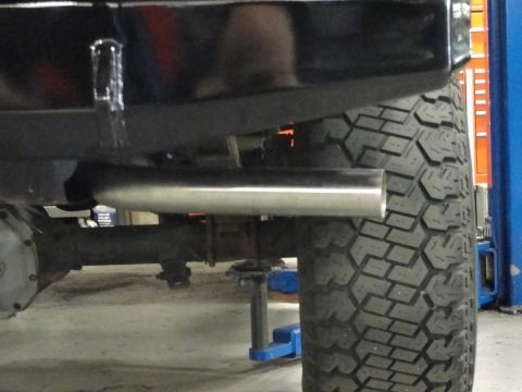 1995 Ford Bronco - The rear tire and exhaust system of a vehicle are shown in this close-up view.