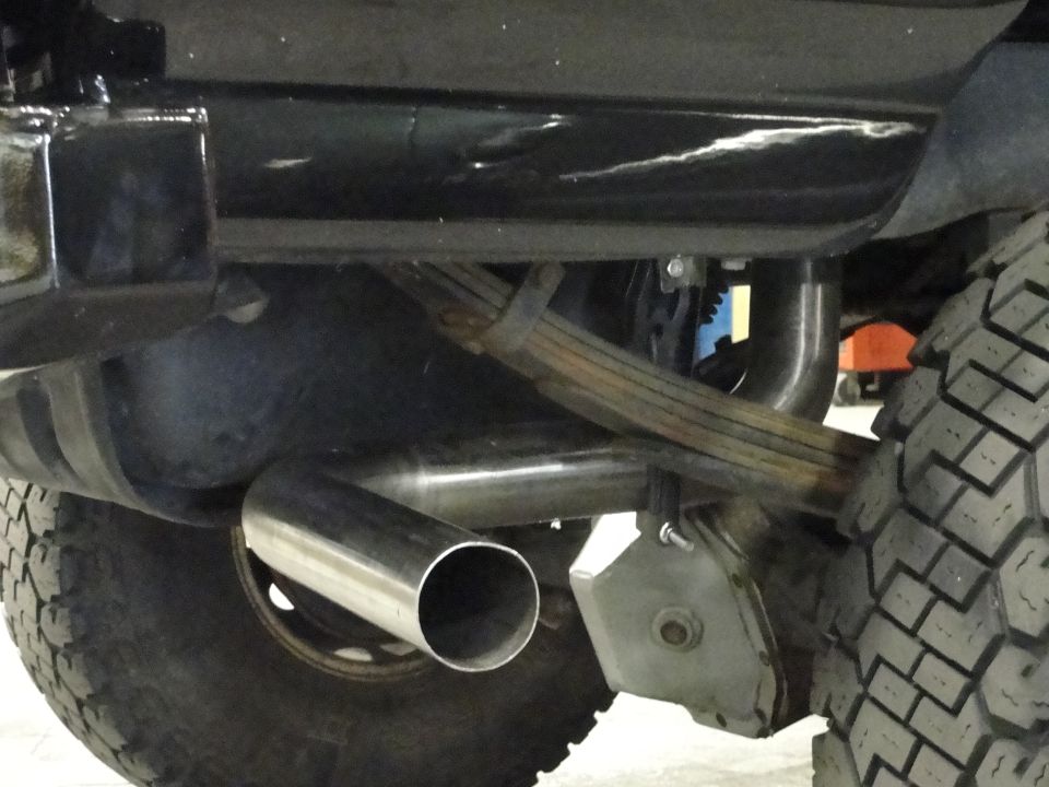 Exhaust pipe and leaf spring on a vehicle