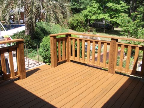 1992 Ford F-150 - Corner of a freshly stained wooden deck with baluster railing, looking out over a backyard with a palm, hedges and a pool. No vehicle or ve…
