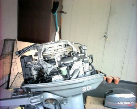 1985 Ford Bronco - An outboard motor is shown in a workshop setting with a broom in the background.