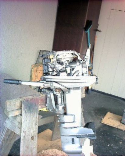 1985 Ford Bronco - An outboard motor is shown mounted on wooden supports, with its engine block and lower unit visible.