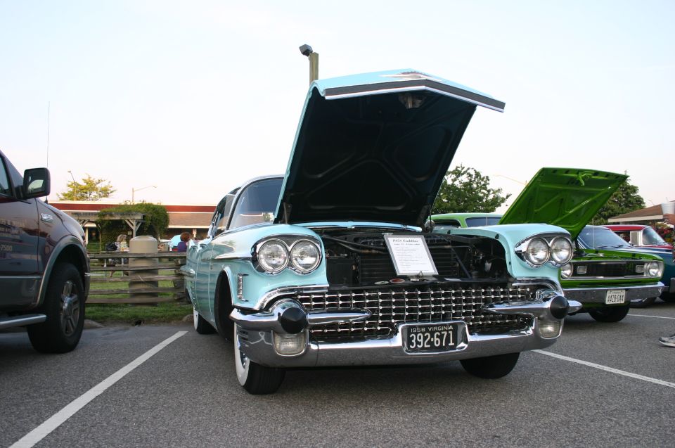 Light blue 1957 Cadillac sedan with hood open, chrome grille, dual headlights, and Virginia license plate 392-671