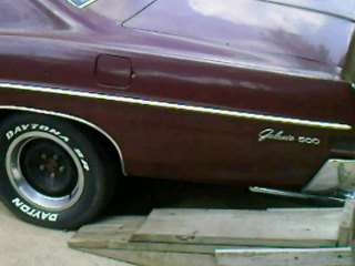 1993 Mercury Grand Marquis - Rear quarter panel of a maroon sedan, identified as a Galaxie 500, with Daytona tires visible.